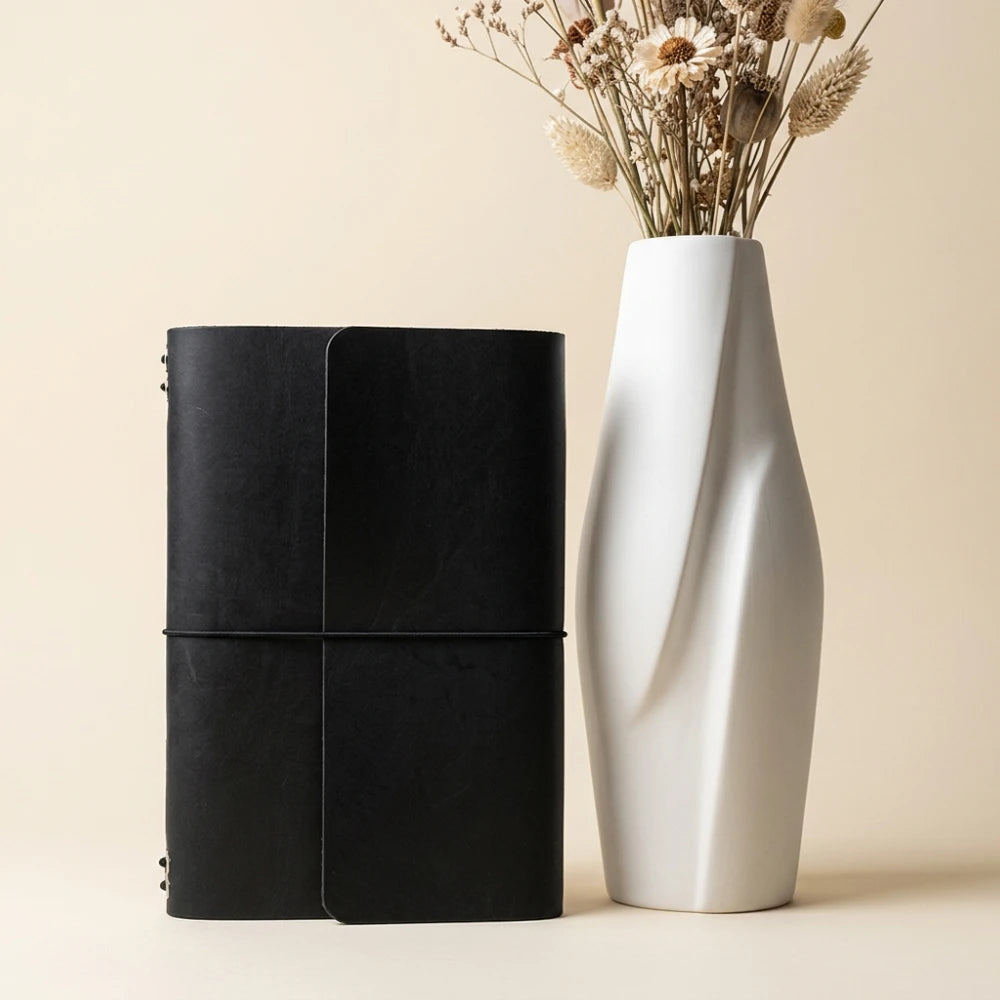 Refillable notebook case crafted from genuine leather with six interior elastic bands.