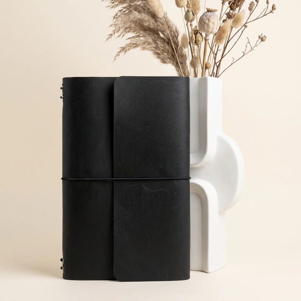 Handmade journal sleeve with six stretch bands for securely carrying refillable notebooks.