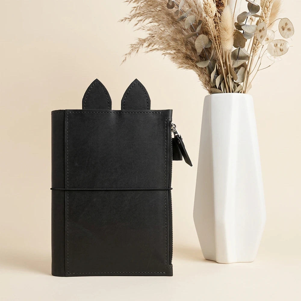 Handmade leather planner cover combining triple elastics with spacious zipper organization.