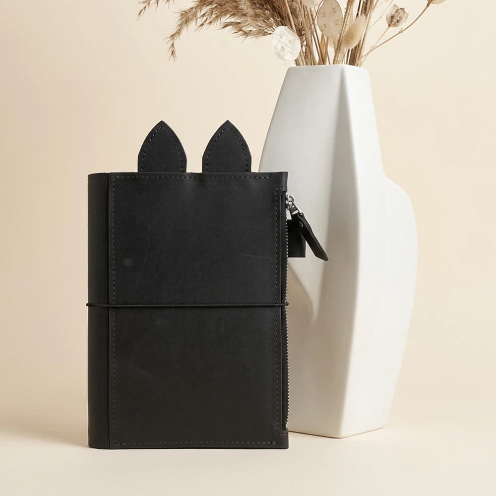 Genuine leather planner cover with reinforced stitching around its large zippered compartment.