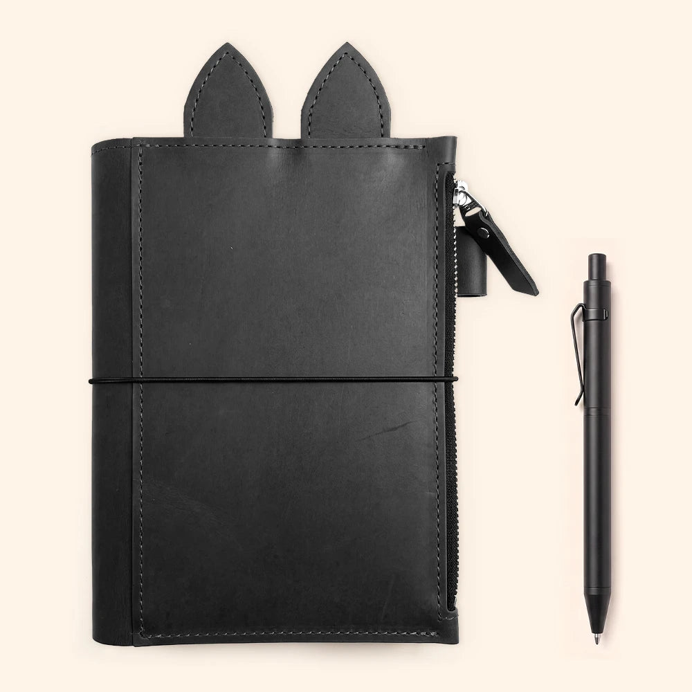 Black leather notebook holder featuring decorative ears and a practical pen loop.
