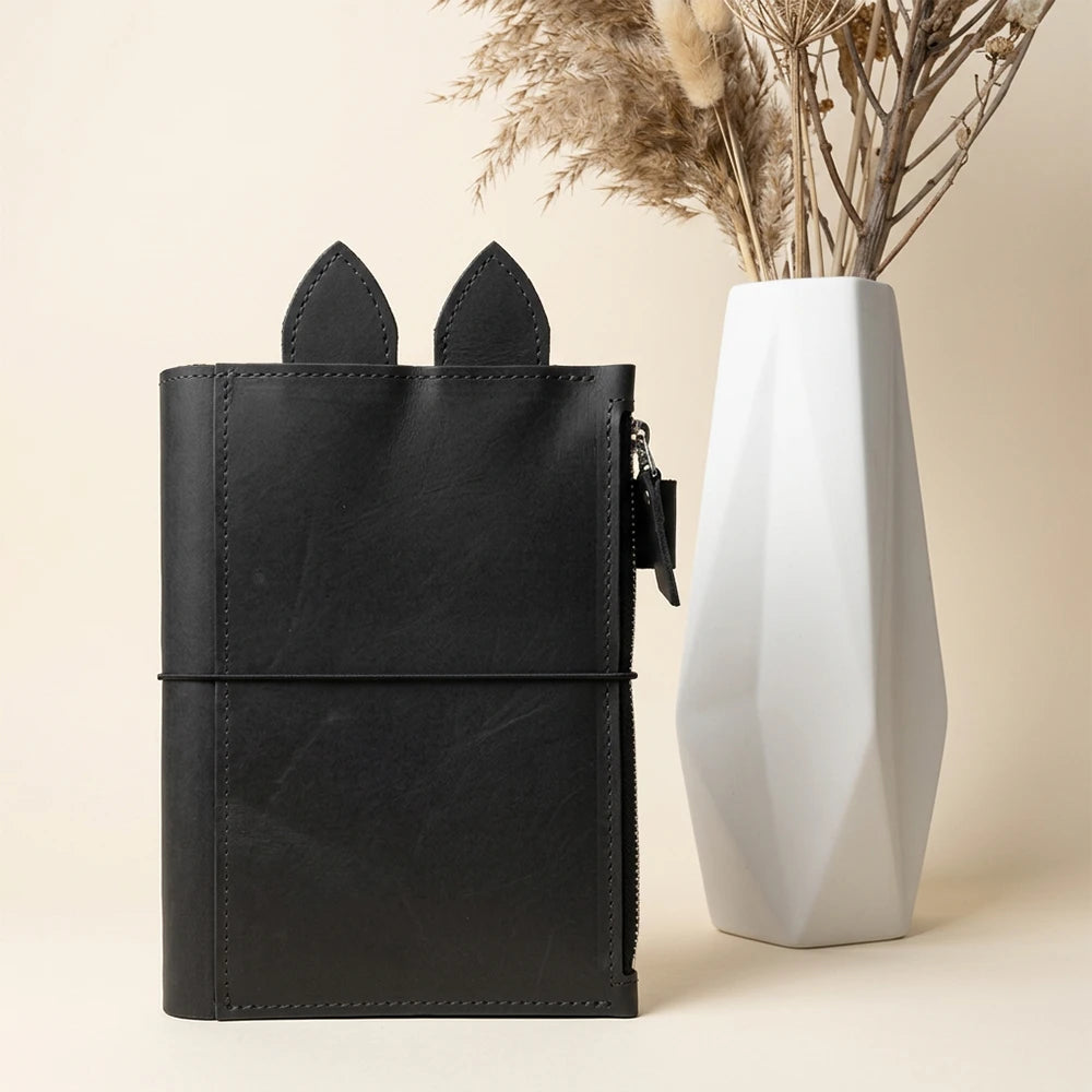 Handcrafted planner case combining playful leather details with practical everyday organization.
