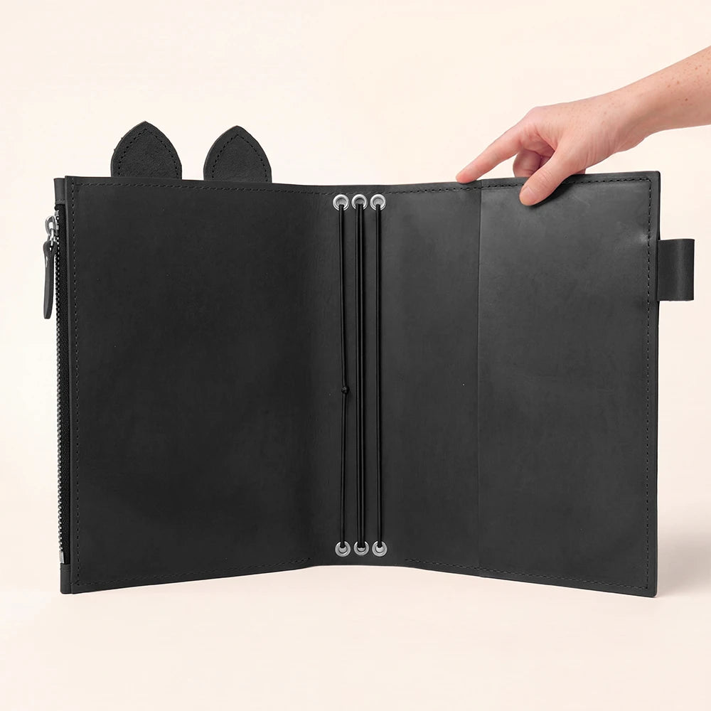 Black leather journal cover with a large interior pocket closed by zipper.