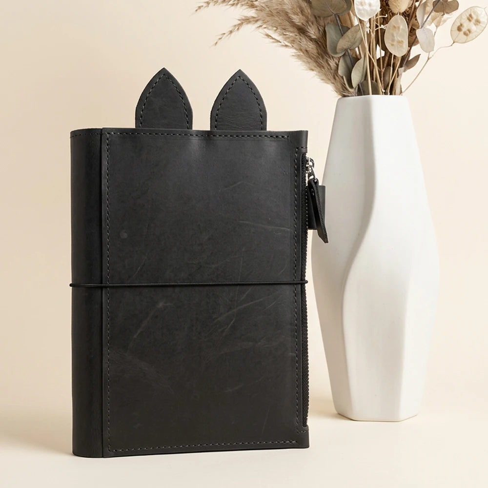 Handcrafted journal organizer featuring natural leather texture, zipper storage, and elastic holders.