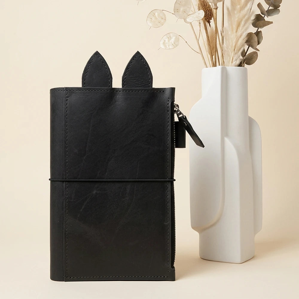 Leather organizer featuring three vertical elastics secured with reinforced metal hardware.
