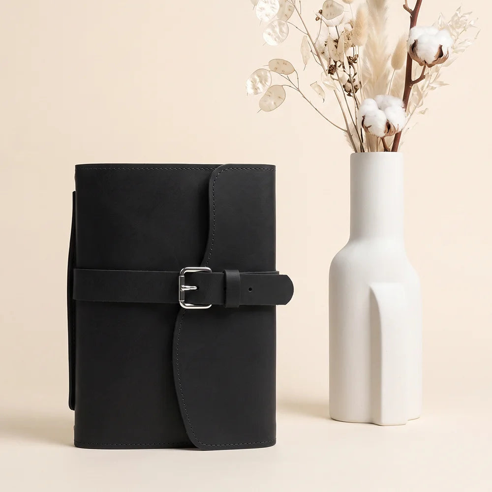Leather journal case showcasing storage pockets, elastic pen loop, ribbon bookmark, and comfortable outer grip.