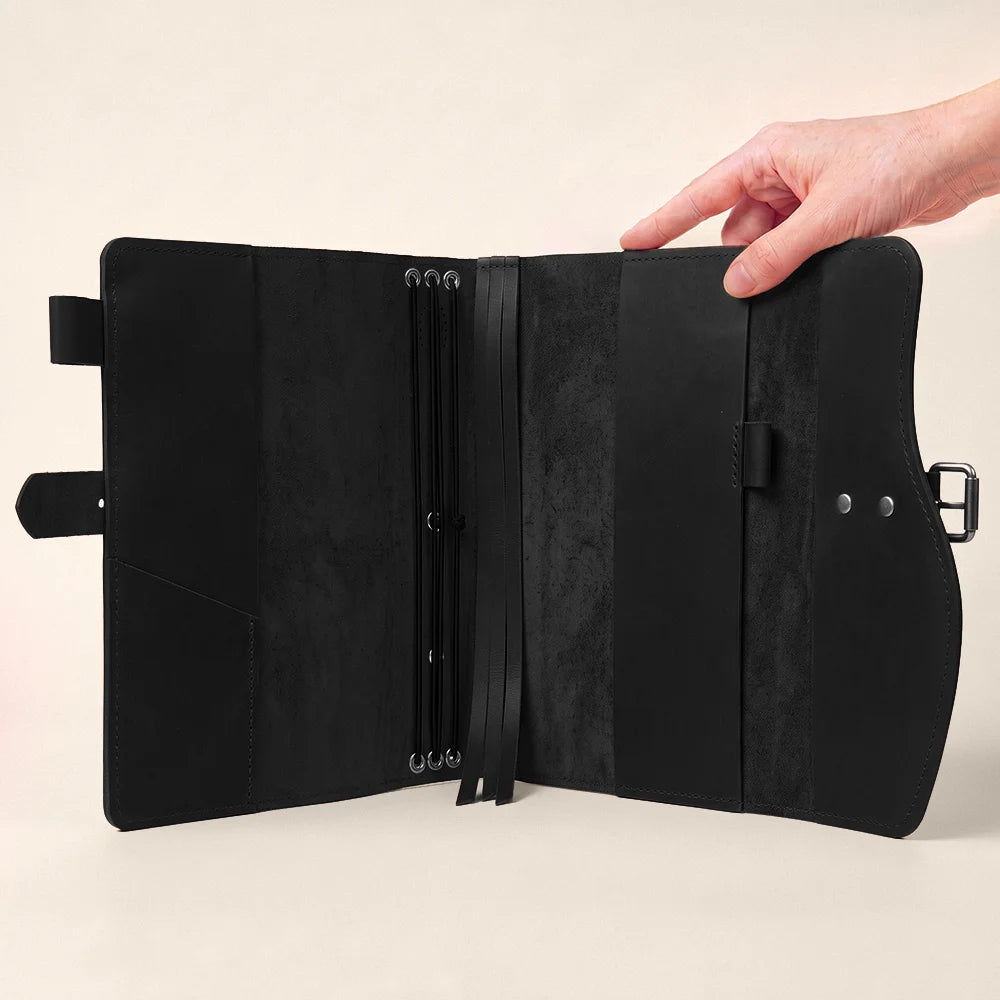 Natural leather planner cover with organized pockets, pen loop, integrated page marker, and carrying strap.