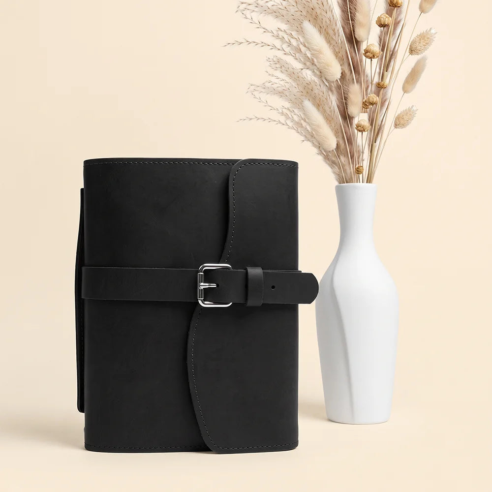 Leather notebook organizer showing functional storage spaces, secure pen holder, sewn bookmark, and convenient carrying strap.