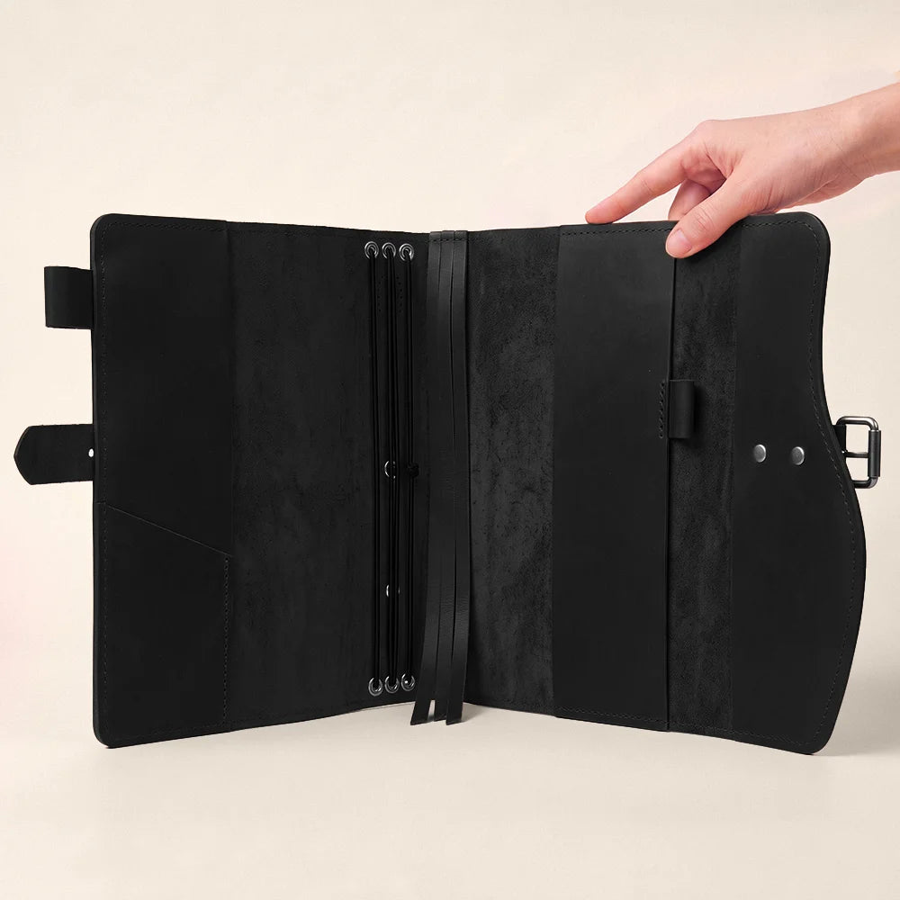 Leather writing cover displaying functional storage pockets, pen loop, bookmark ribbon, and comfortable carry grip.