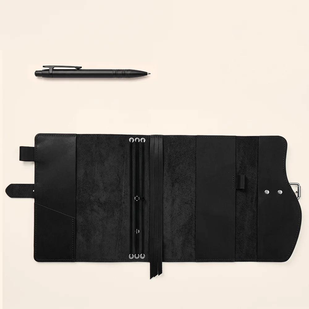 Handmade leather notebook sleeve with useful compartments, secure pen keeper, attached page marker, and carrying strap.