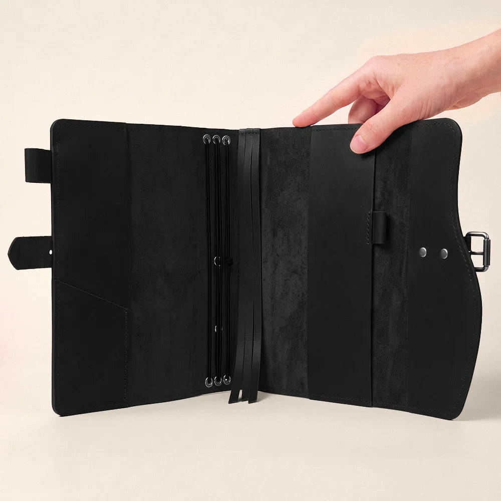 Natural leather planner case with organized storage spaces, pen attachment, integrated bookmark, and durable carrying handle.