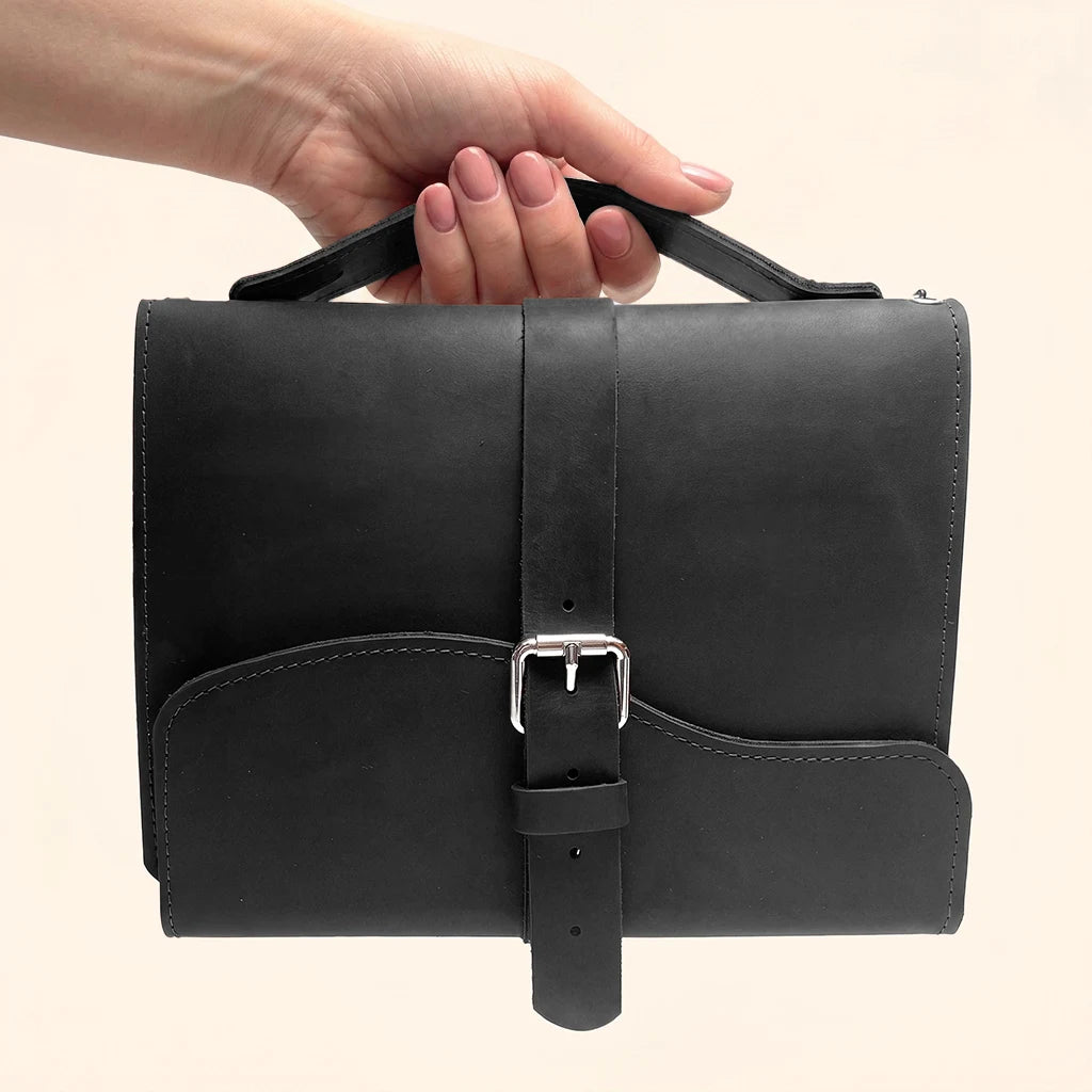 Genuine leather notebook cover with three elastic bands and a convenient carrying handle.