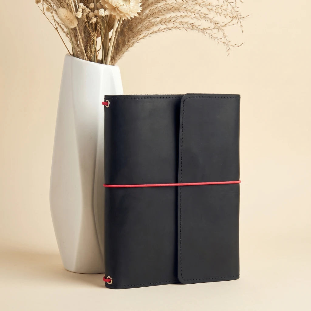 Artisan leather notebook wrap featuring elastic fastening and interior storage pockets