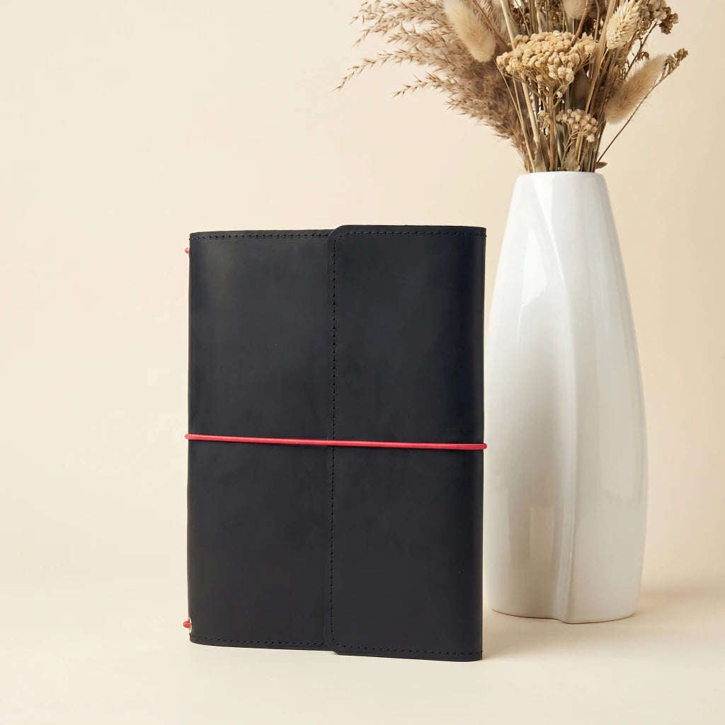Minimal leather journal cover with elastic straps and organized interior pockets