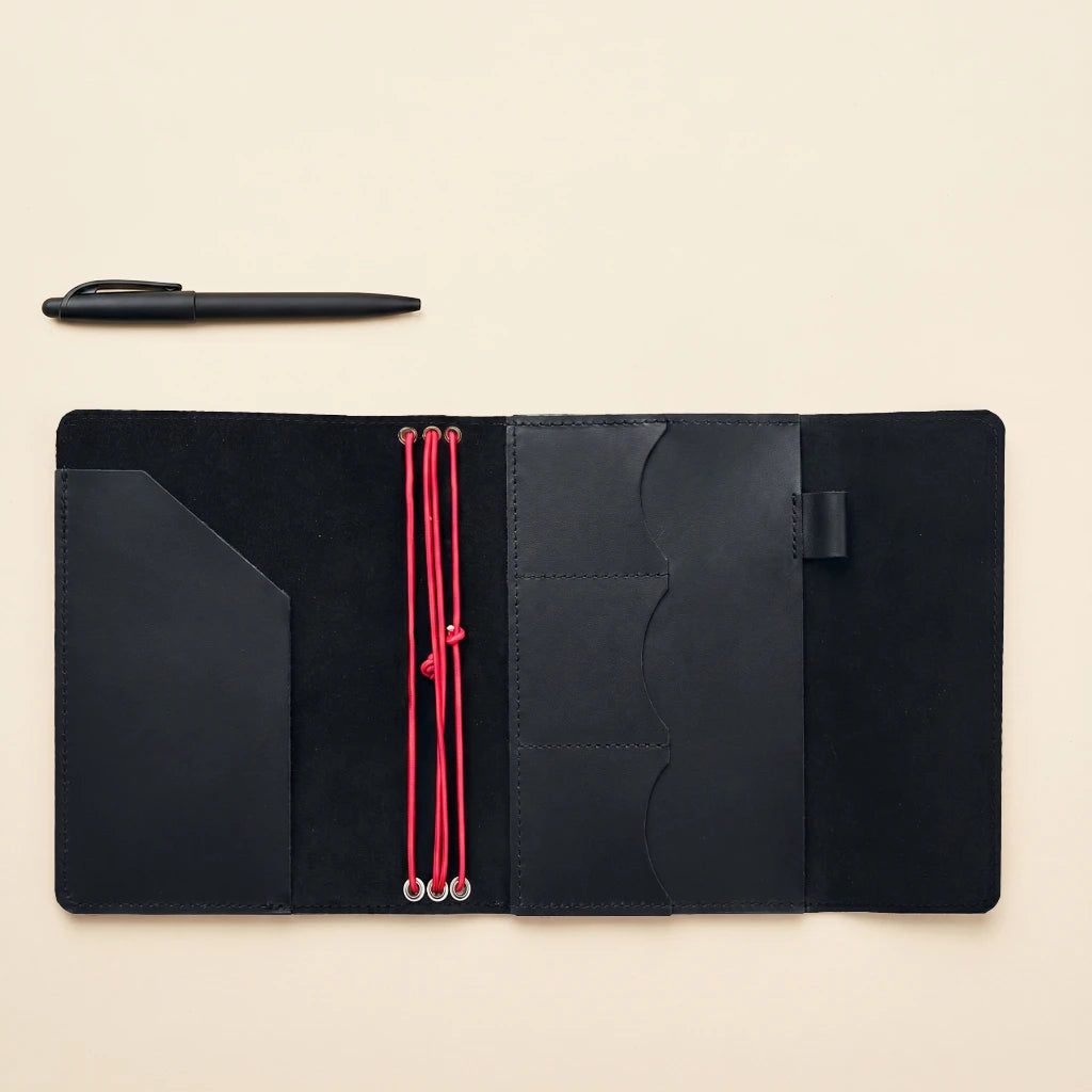 Handmade leather notebook protector with elastic straps and organized pocket layout