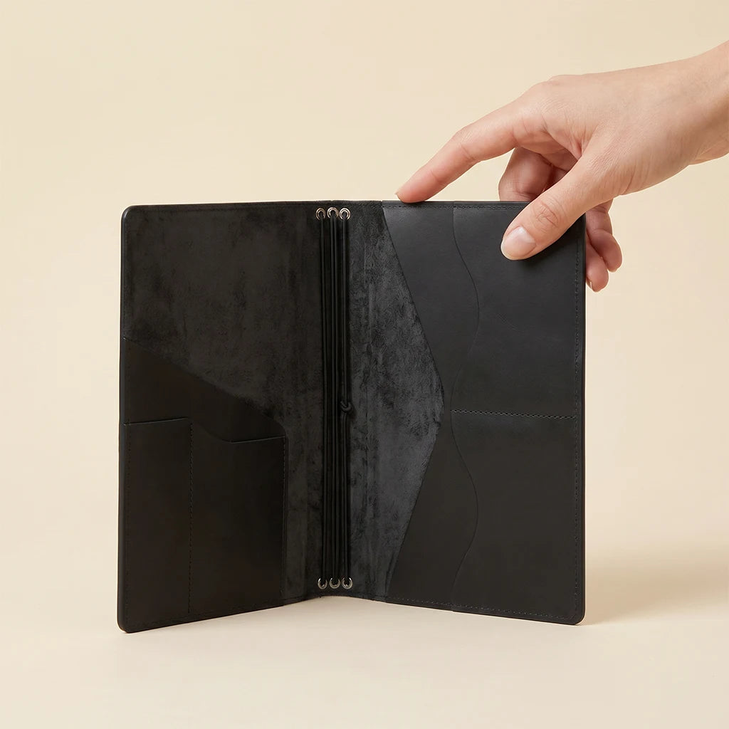 Handmade leather writing journal cover with integrated storage compartments.