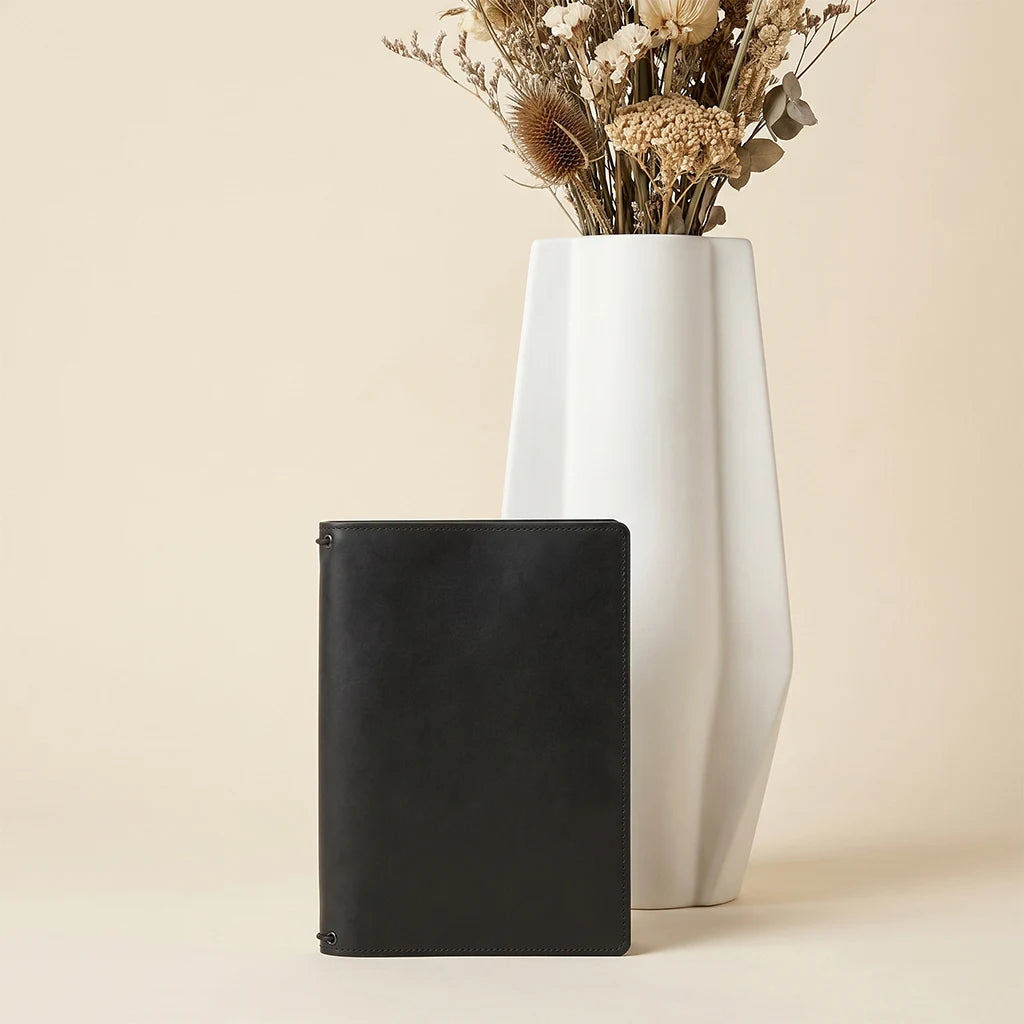 Leather notebook cover featuring refillable design and interior card slots.