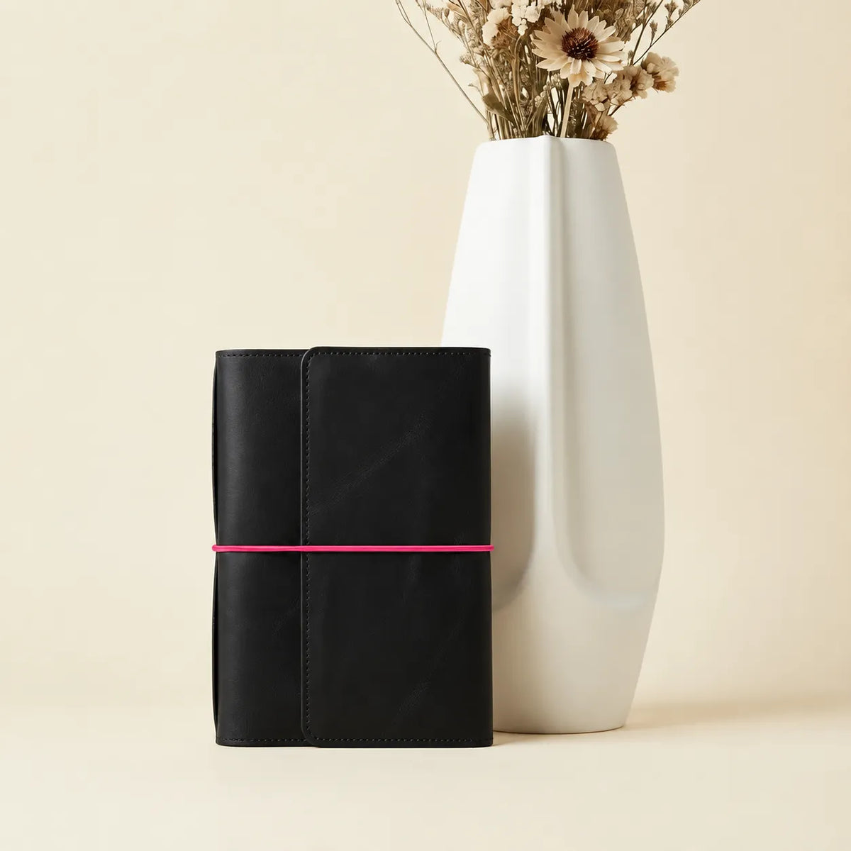 Handmade black leather notebook cover featuring stylish pink elastic closures