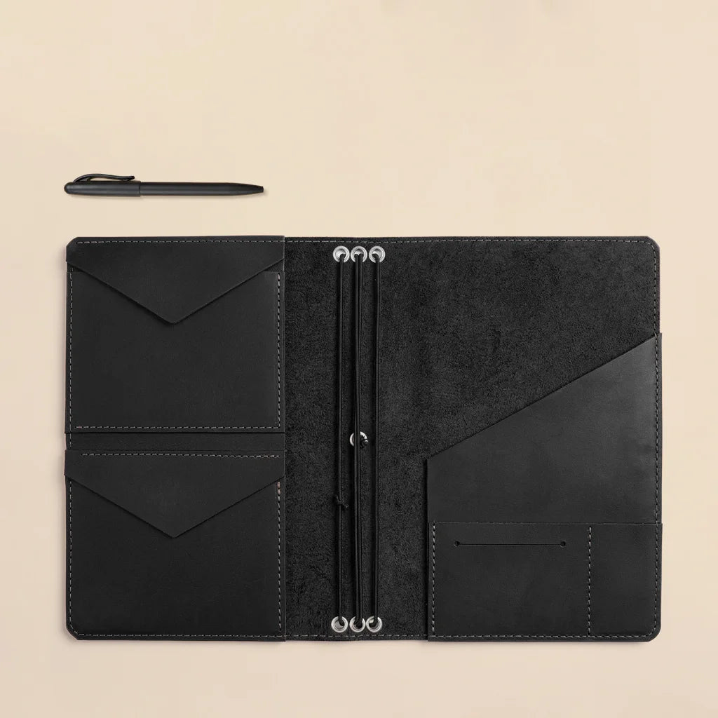 Handmade leather notebook organizer with refillable elastic bands and elegant pocket construction.
