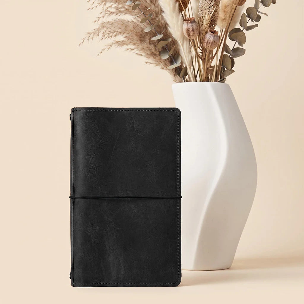 Genuine leather refillable planner cover with organized compartments and notebook retaining elastics.