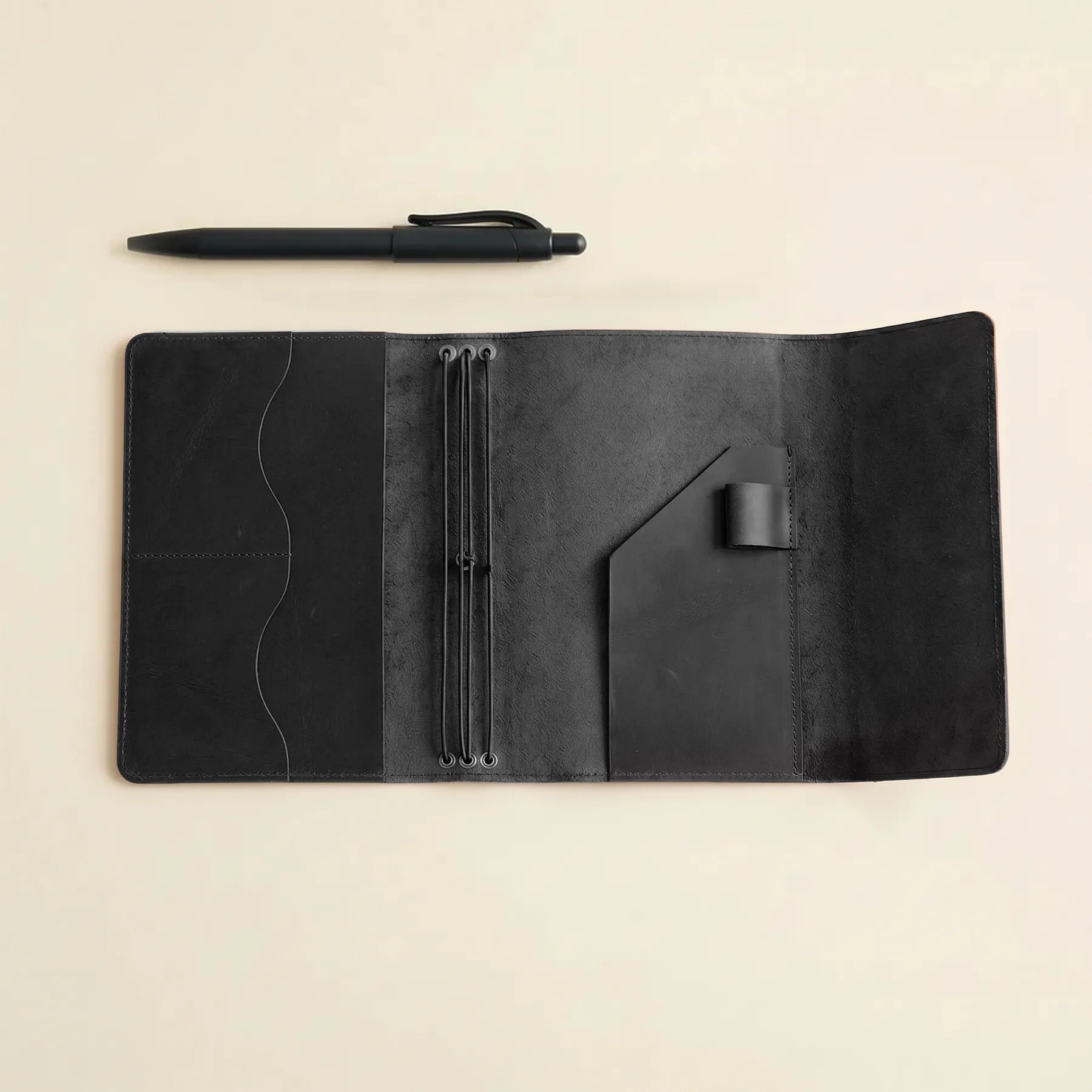 Refillable leather journal featuring elastic notebook inserts and storage pockets.