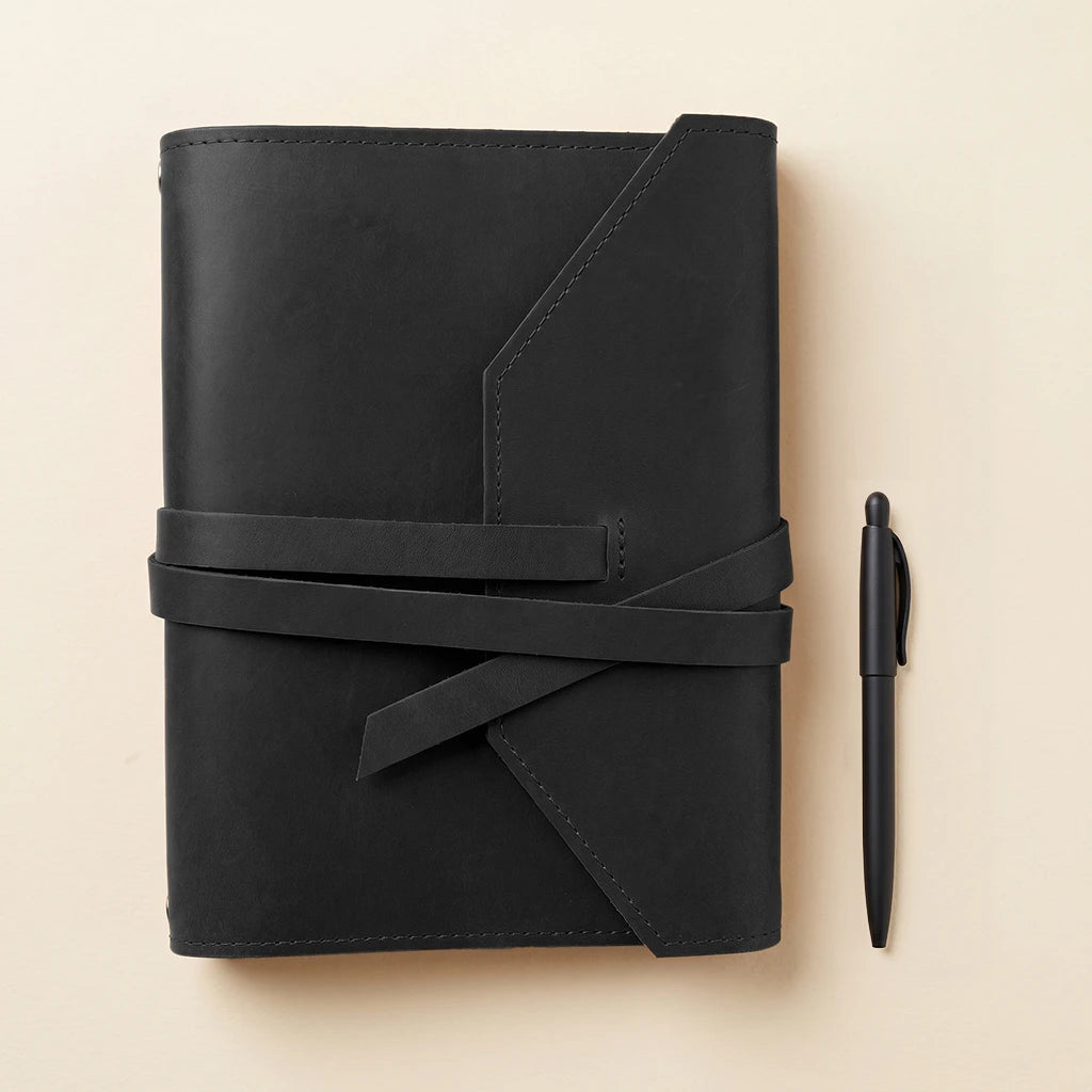 Leather journal organizer with elastic cord system and pen holder feature.