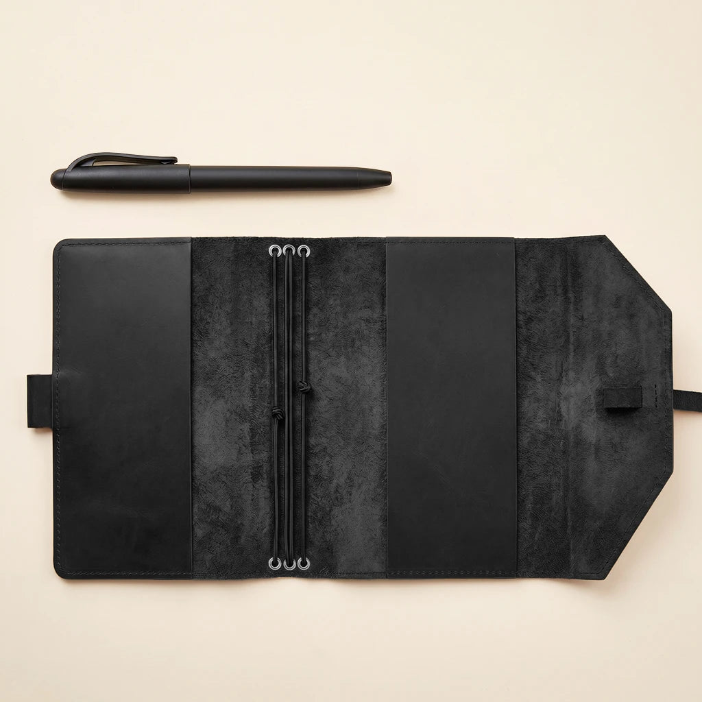 Rustic leather notebook cover with elastic fastening and built-in pen loop.