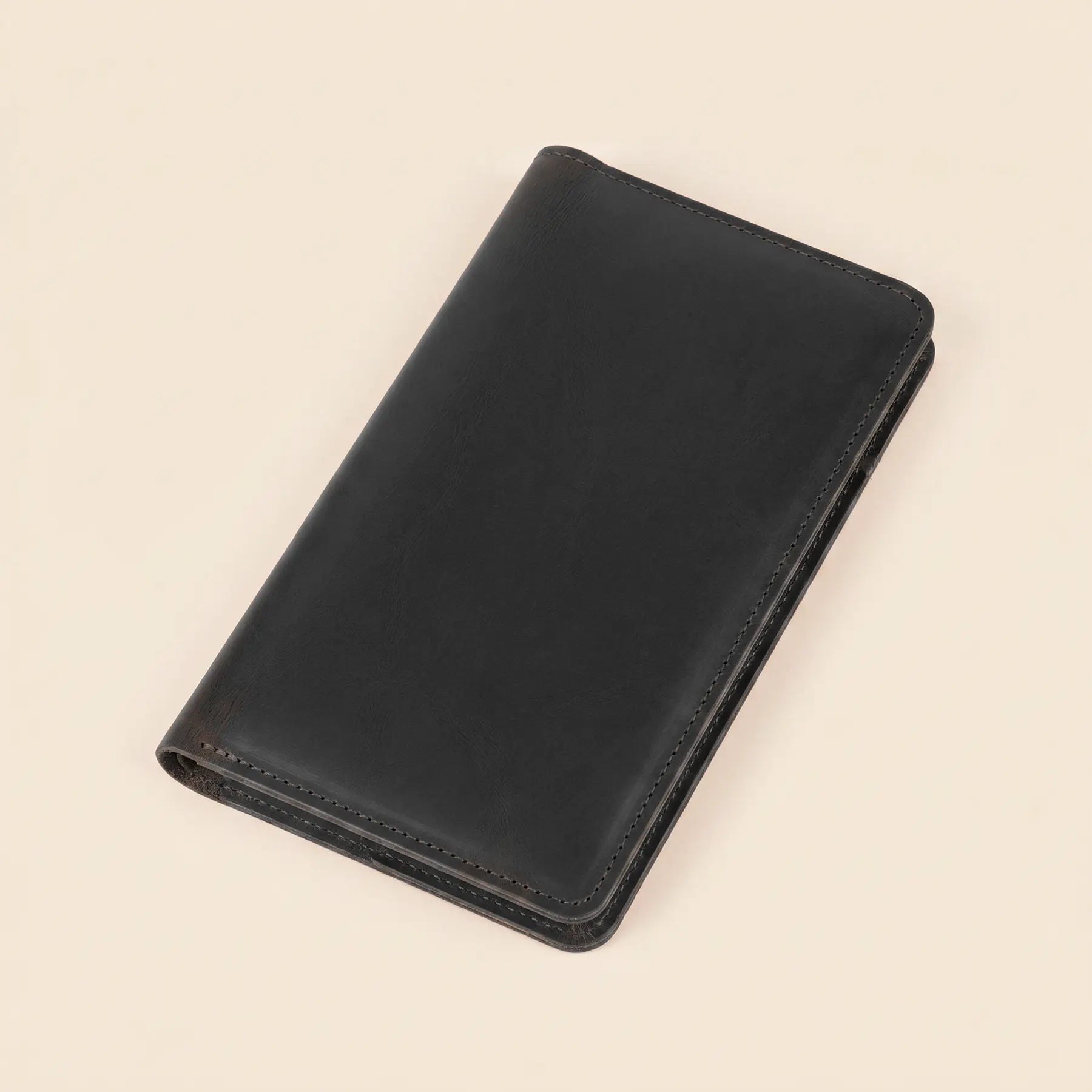 Handcrafted genuine leather wallet featuring snap closure, functional compartments, and elegant minimalist long design.