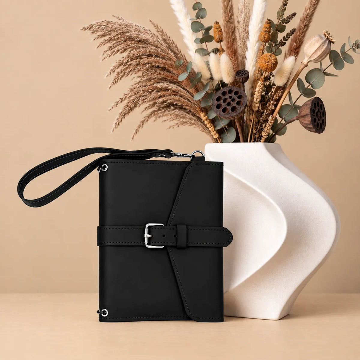 Natural leather notebook holder featuring interior pockets and a convenient leather wrist strap