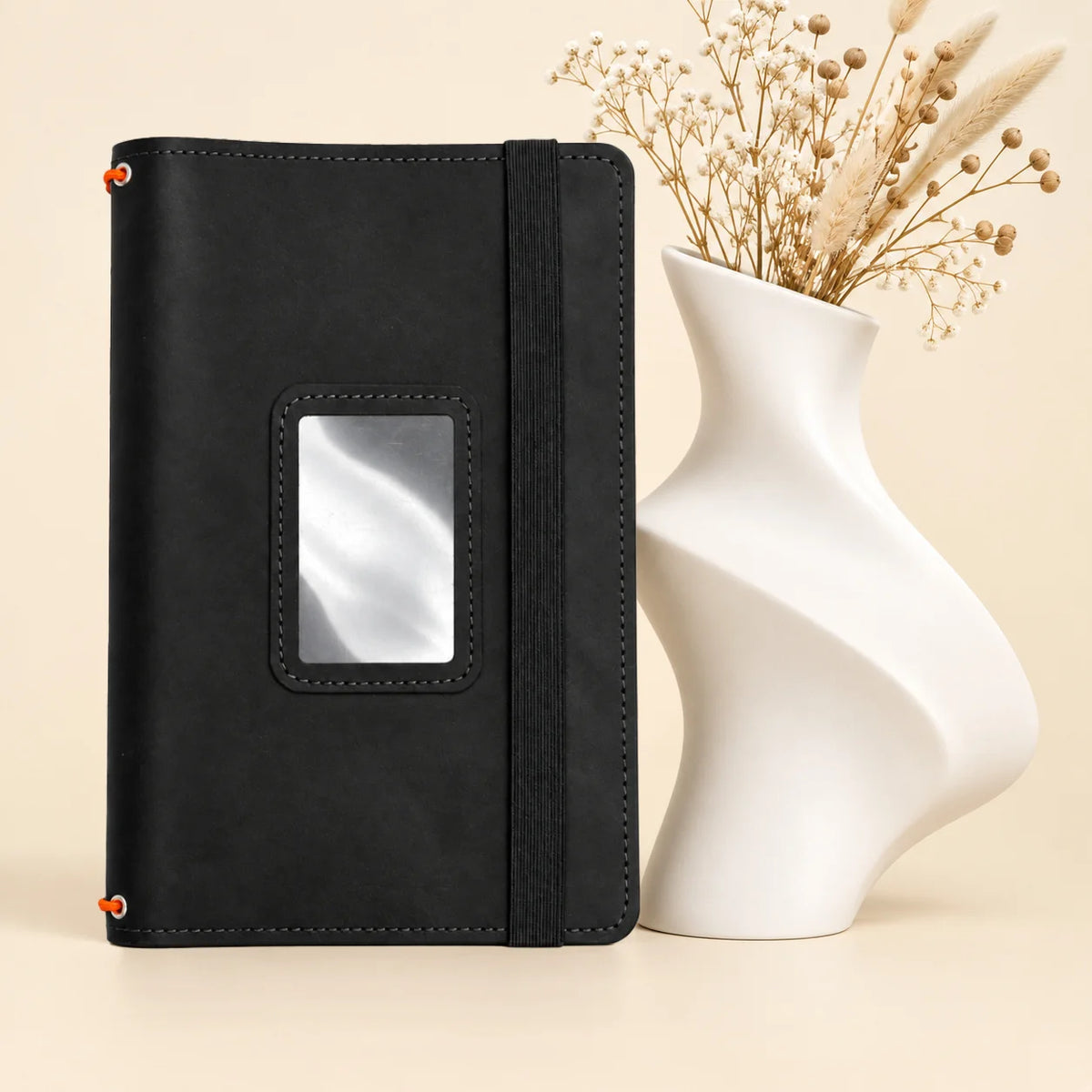 Natural leather notebook holder featuring three secure straps and organized pockets for everyday items.