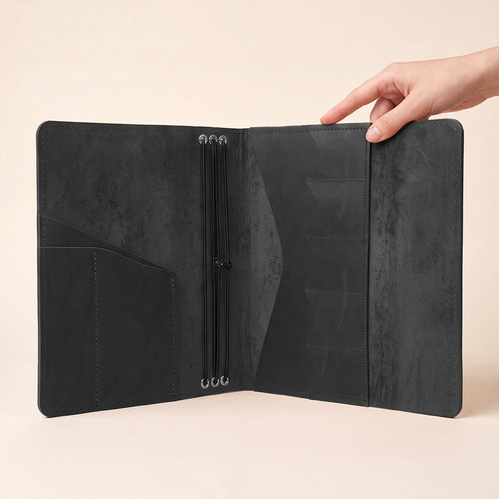 Handcrafted leather notebook portfolio featuring interior pockets and refillable elastic journal system.