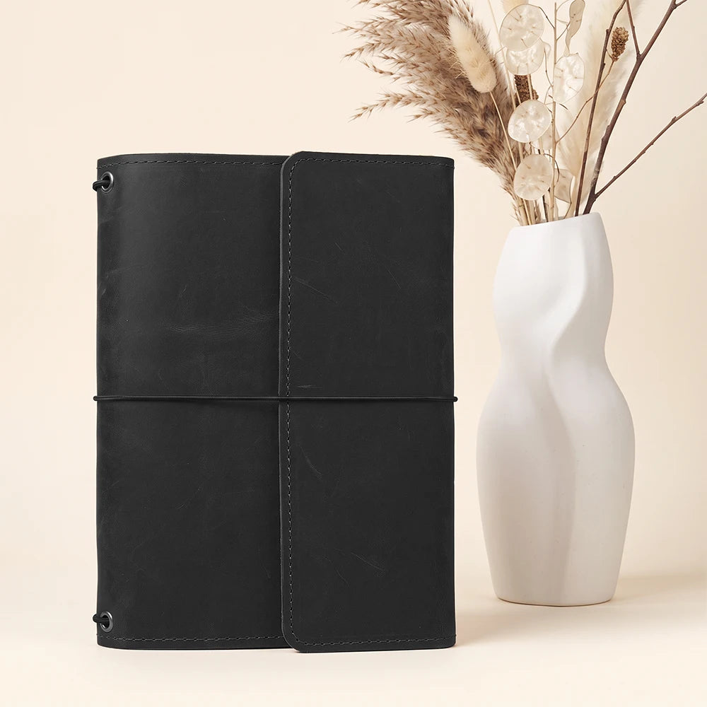 Genuine leather notebook holder with clean design and convenient storage for writing essentials.