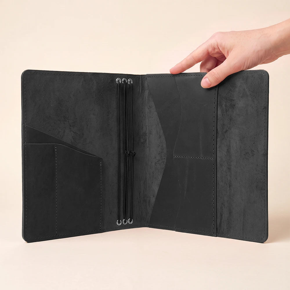 Elegant leather planner holder with elastic journal inserts and spacious interior organization features.