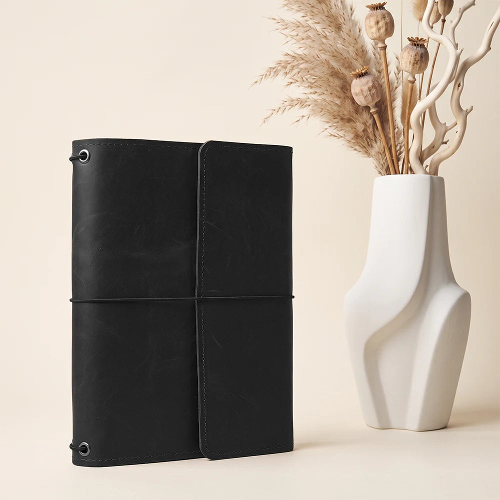 Refillable leather planner organizer with convenient inside pockets and secure elastic notebook system.