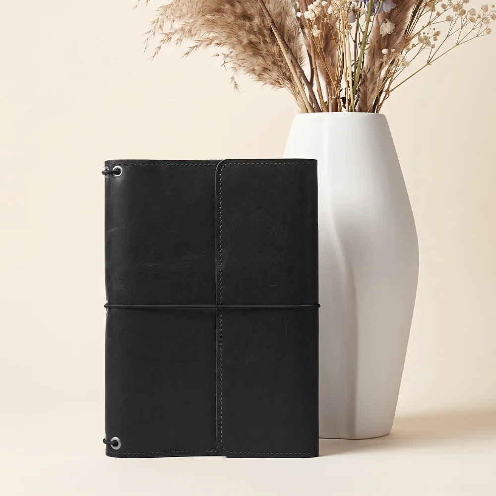 Leather travel notebook organizer with secure elastic bands and premium handcrafted leather finish.