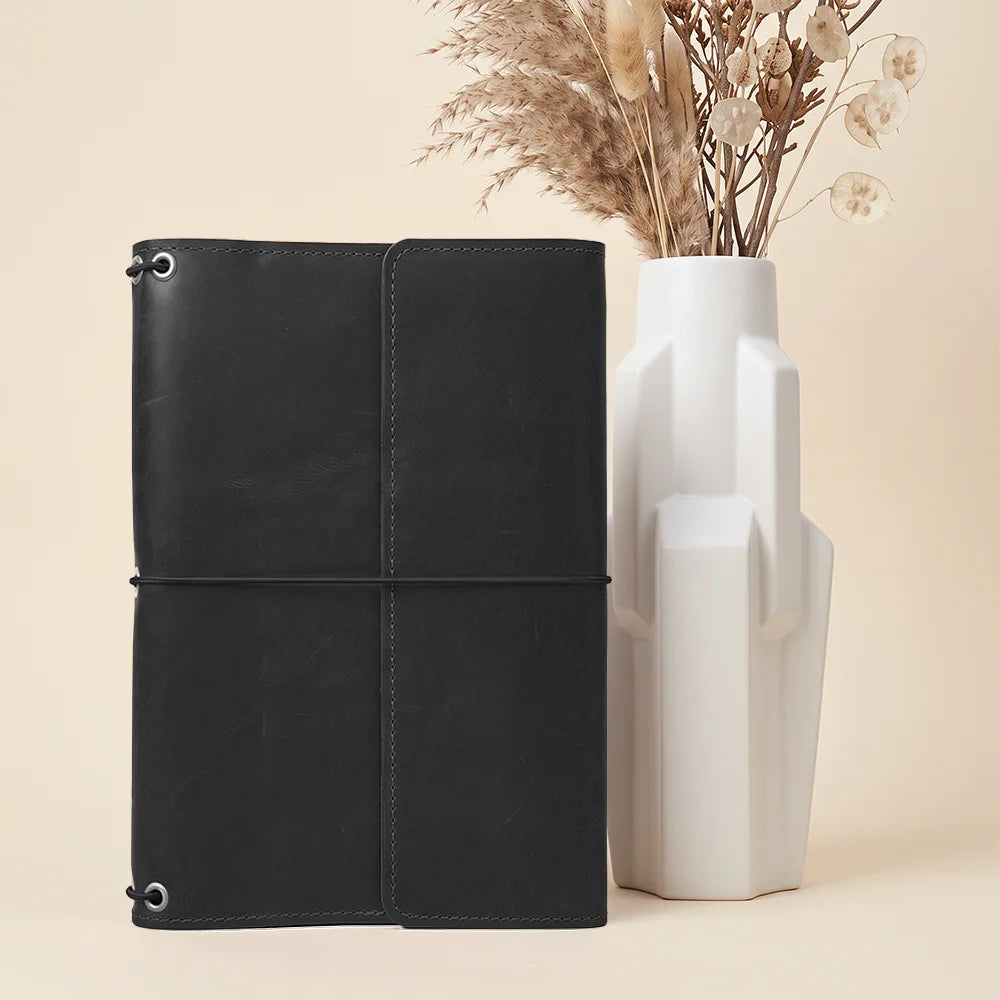 Handcrafted leather organizer cover with refillable notebook system and functional storage compartments throughout.