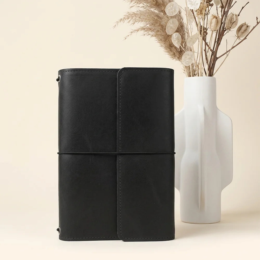 Leather notebook holder featuring several useful compartments and an integrated loop for writing tools.