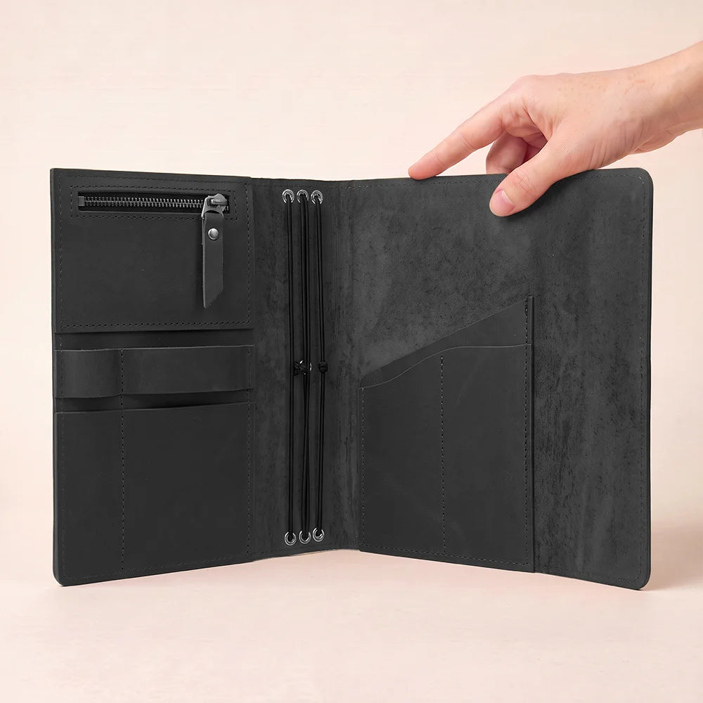 Handmade leather planner cover featuring functional storage sections and a convenient writing accessory loop.