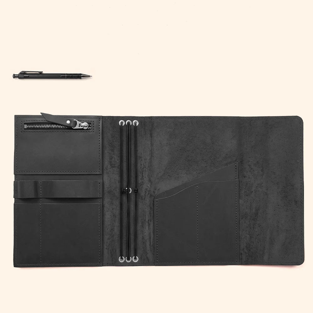 Artisan leather notebook sleeve featuring interior pockets and a securely attached pen retaining strap.