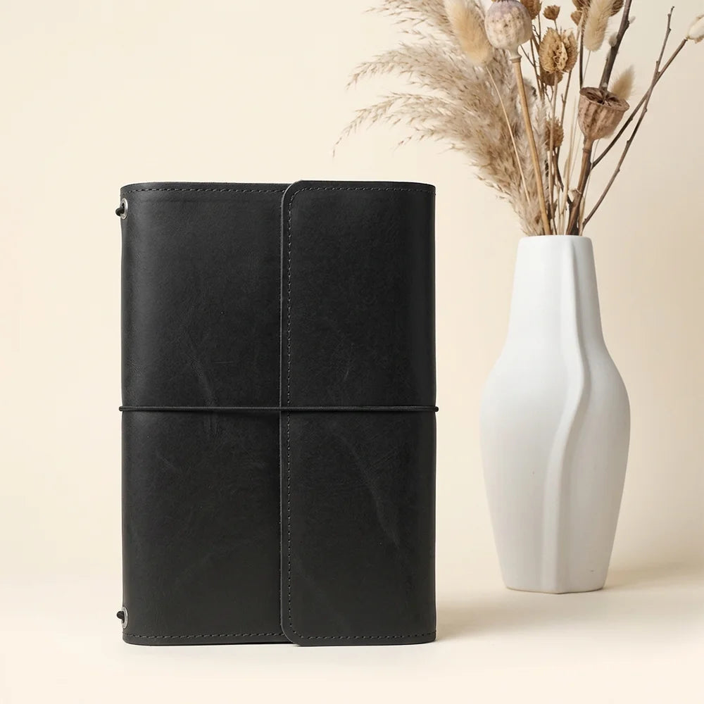 Handmade leather journal sleeve showcasing useful interior pockets and a dedicated writing accessory loop.
