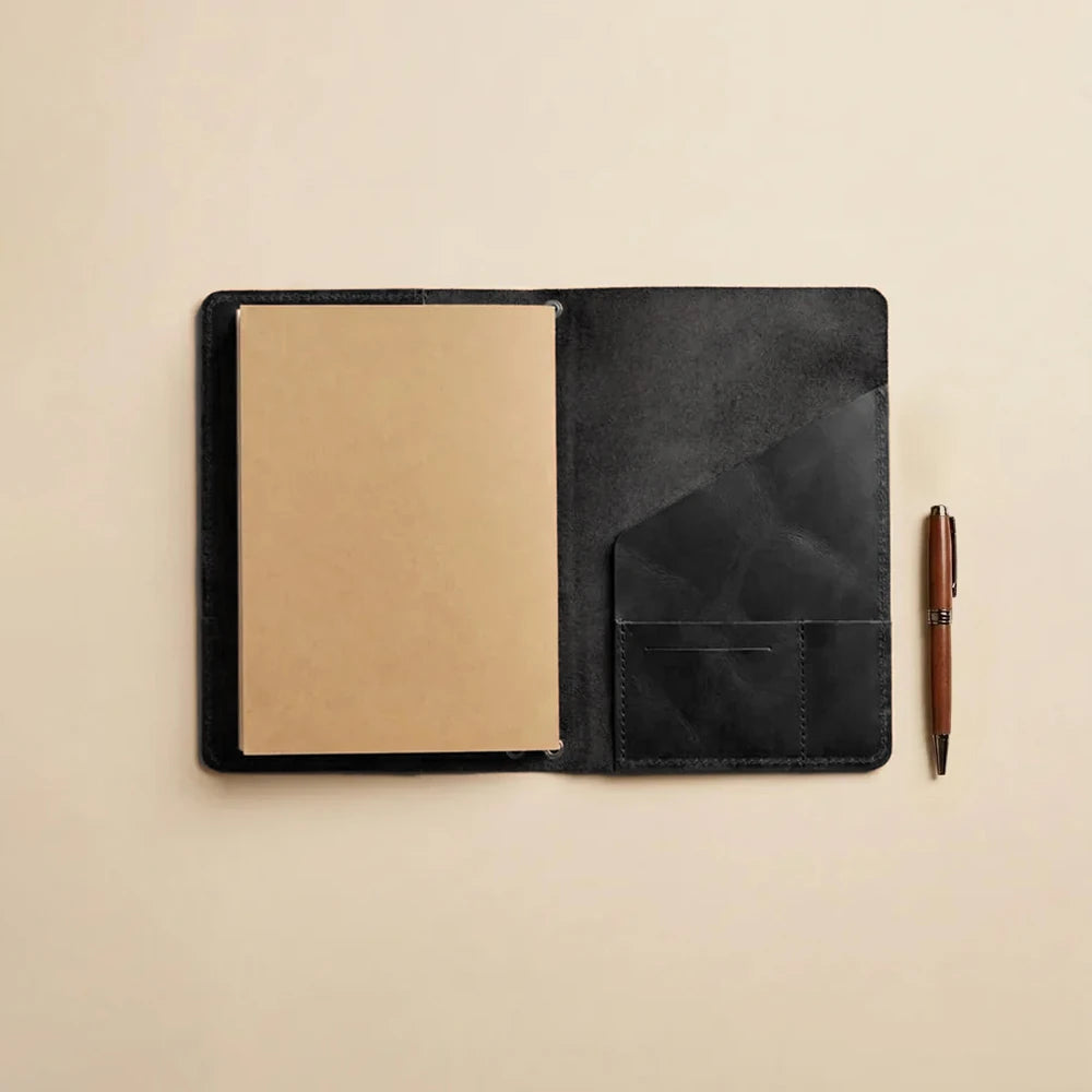 Premium leather notebook protector with elastic inserts and organized interior pocket configuration.