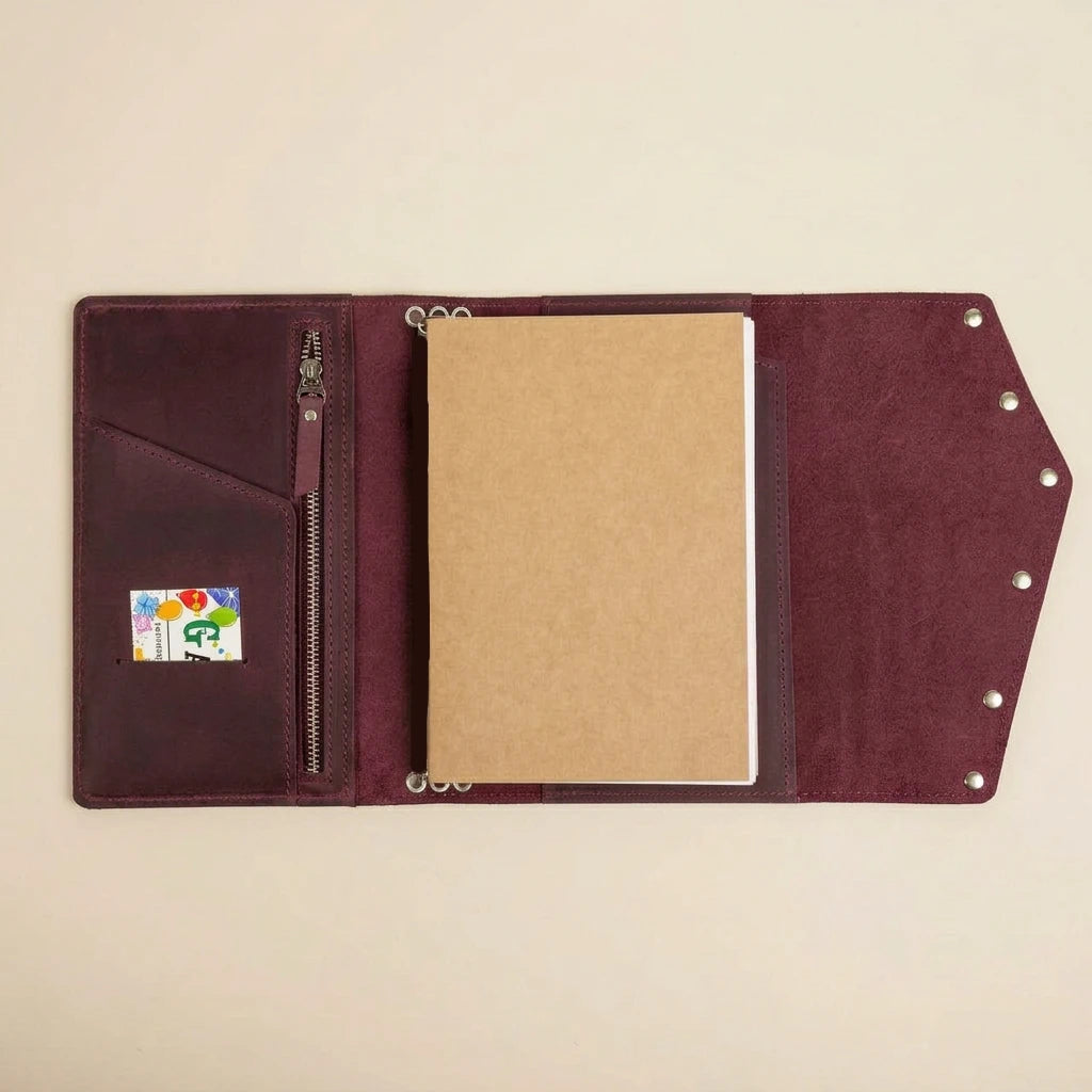 Brown leather journal with a zipper pocket on a beige background
