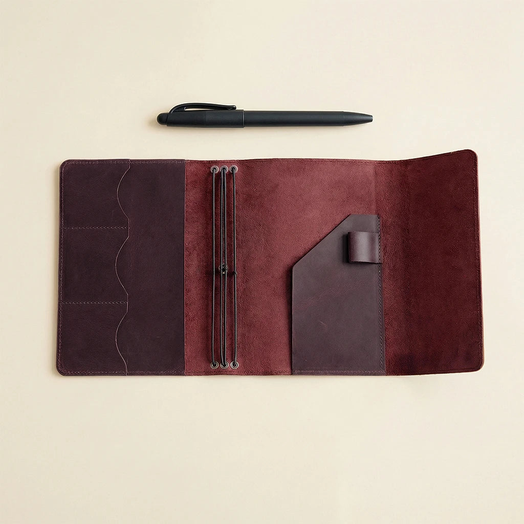 Brown leather organizer with pen and pen holder on a beige background