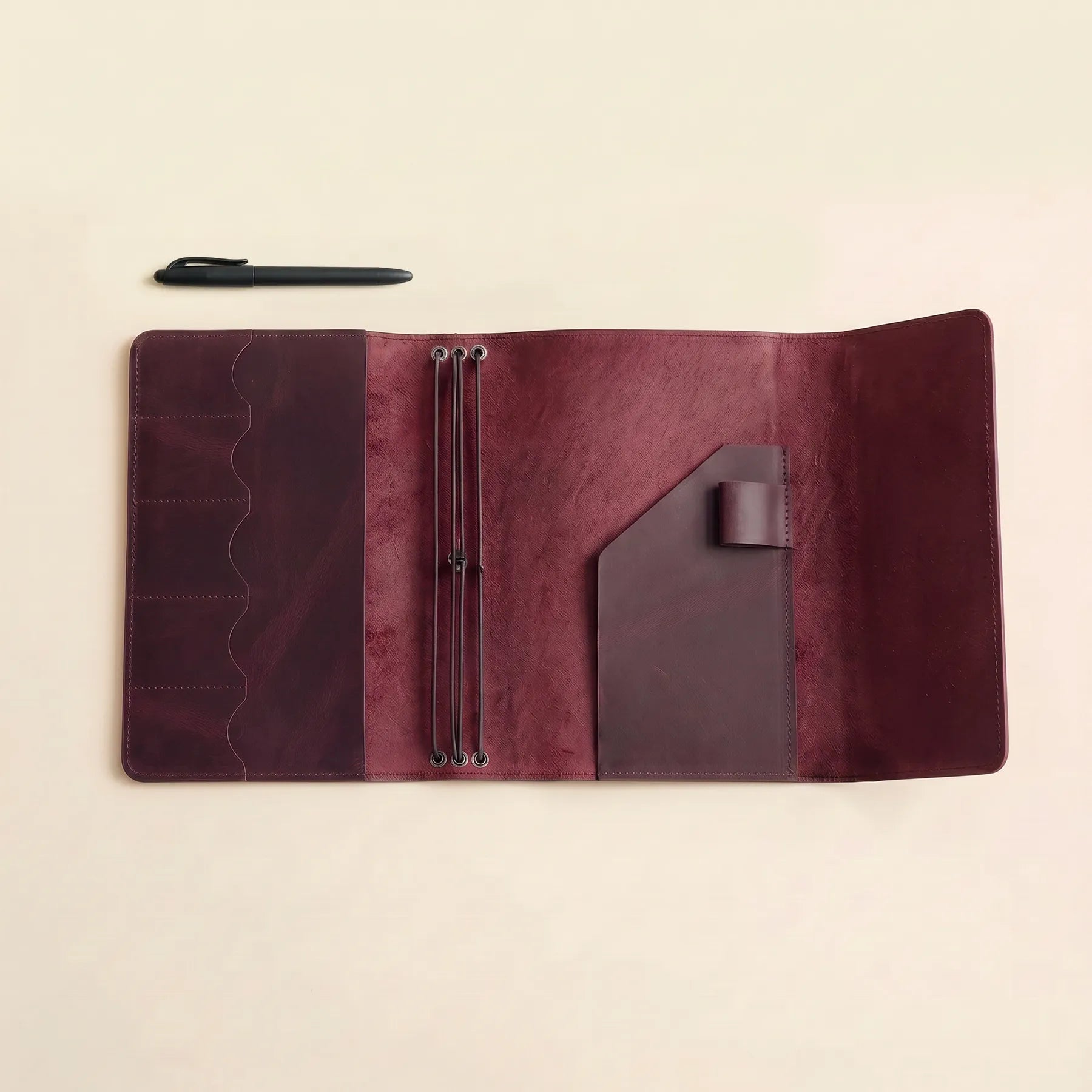Personalized notebook cover crafted from leather with pen holder included.