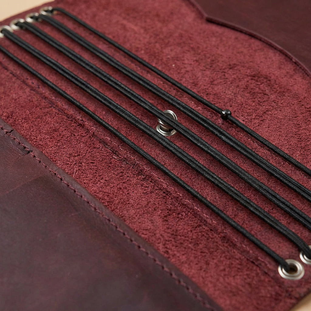 Close-up of a red leather journal cover with black strings