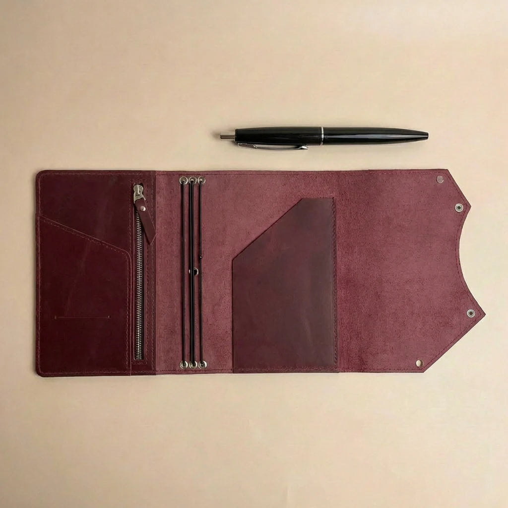 Brown leather journal cover with pen on a beige background