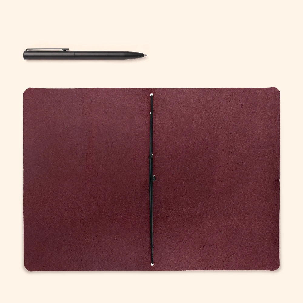 Natural leather writing holder featuring minimalist structure and secure elastic notebook support.