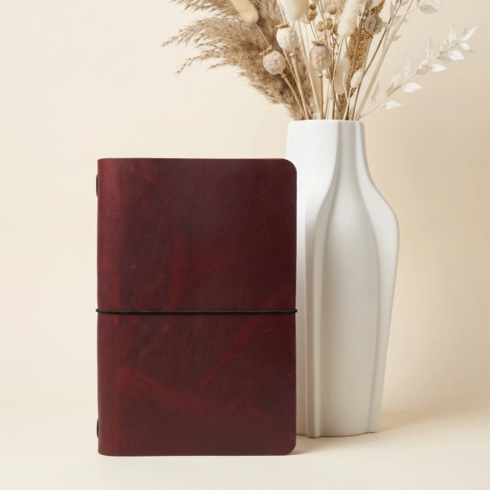 Handmade leather cover showing the notebook held neatly by elastic inside.