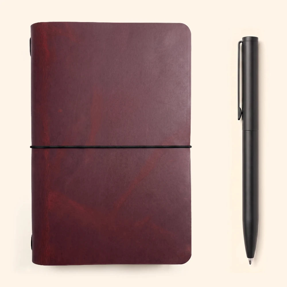 Natural leather notebook case with subtle handcrafted texture and single elastic retention.