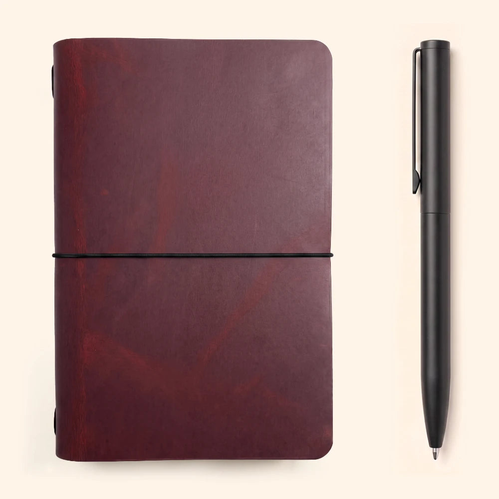 Minimalist handmade leather cover protecting a simple notebook with secure elastic fastening.